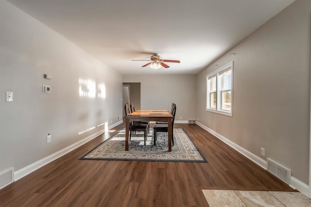 dining room with ceiling fan and dark wood-type flooring