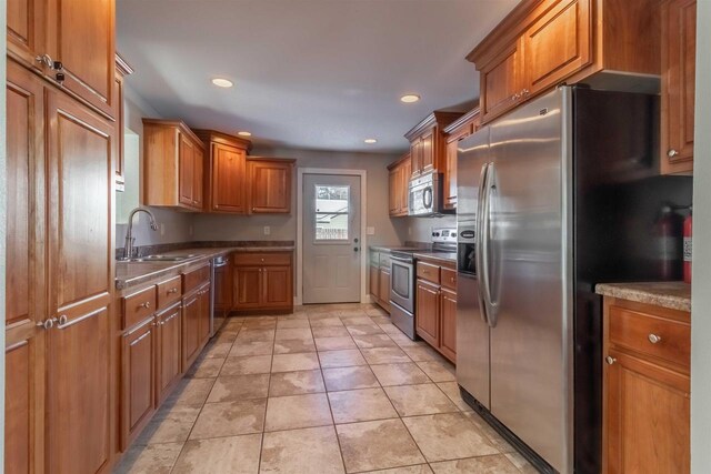 kitchen with light tile patterned flooring, sink, and appliances with stainless steel finishes