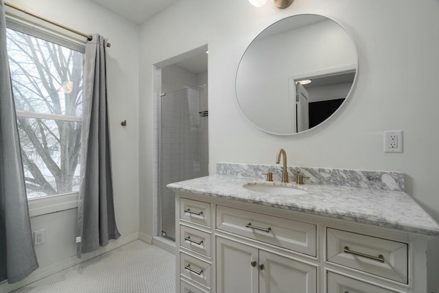 bathroom with tile patterned flooring, vanity, and a tile shower