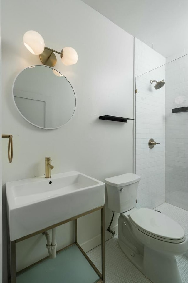 bathroom featuring tiled shower, tile patterned floors, and toilet