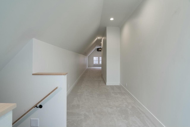 hallway with light carpet and lofted ceiling