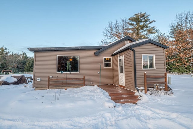 snow covered rear of property featuring a wooden deck