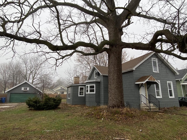 view of front facade with a garage, an outdoor structure, and a front yard