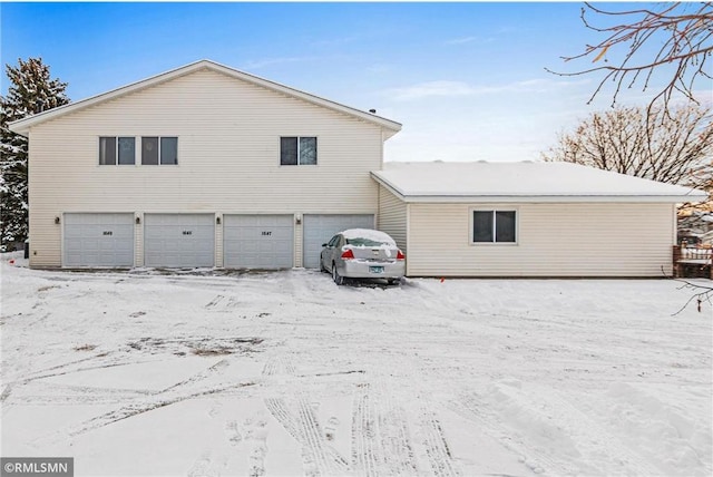 view of snow covered exterior with a garage