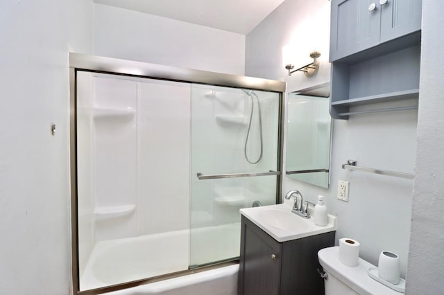 full bathroom with combined bath / shower with glass door, toilet, and vanity