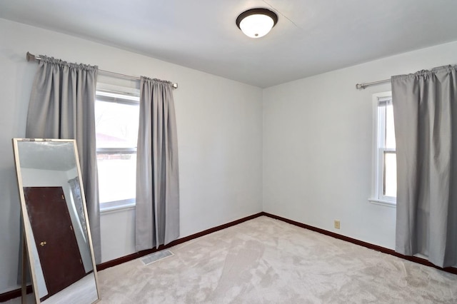 carpeted empty room with a healthy amount of sunlight