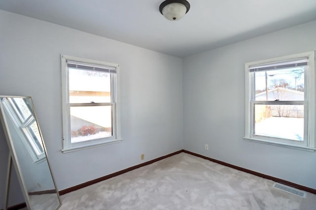 unfurnished room featuring light colored carpet