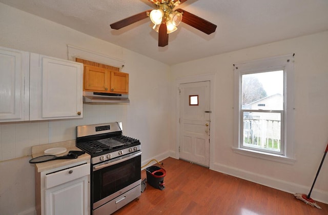 kitchen featuring decorative backsplash, light hardwood / wood-style floors, white cabinetry, and stainless steel range with gas stovetop