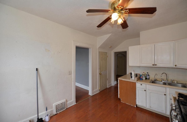 kitchen with white cabinets, sink, stainless steel range oven, tasteful backsplash, and dark hardwood / wood-style flooring