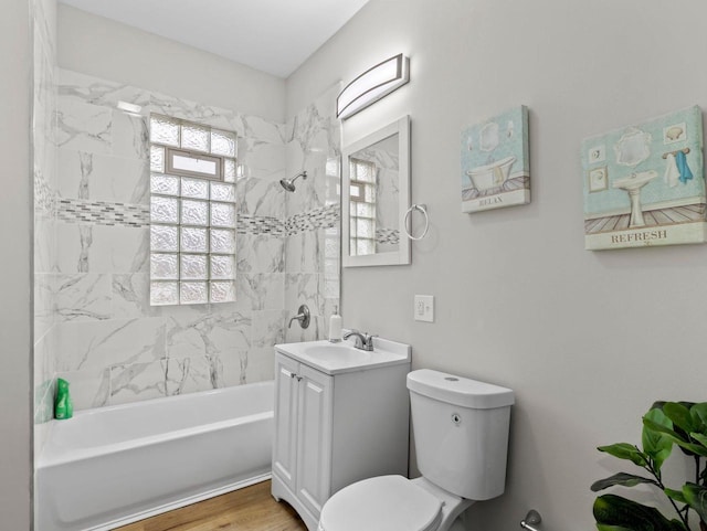 full bathroom with hardwood / wood-style flooring, vanity, toilet, and tiled shower / bath