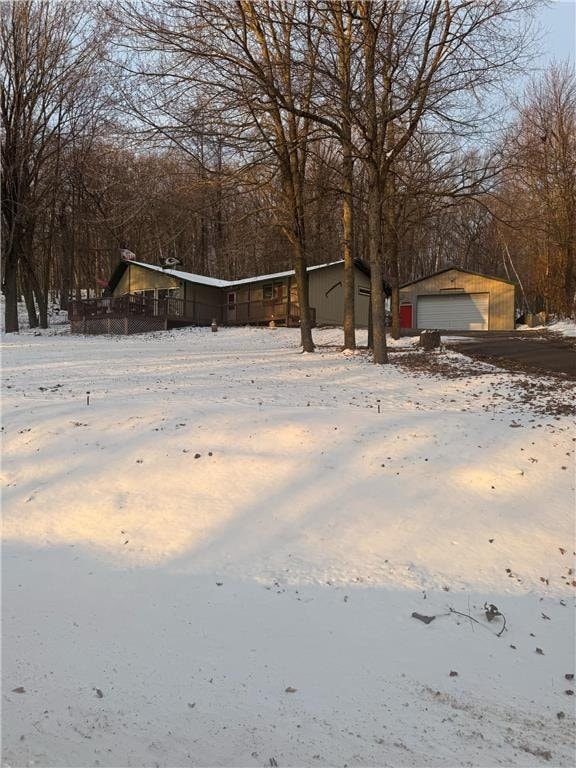 yard covered in snow with an outbuilding and a garage