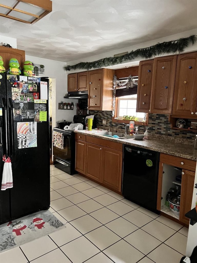 kitchen featuring backsplash, sink, light tile patterned floors, and black appliances