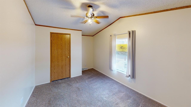 unfurnished bedroom with a textured ceiling, lofted ceiling, carpet floors, ceiling fan, and crown molding