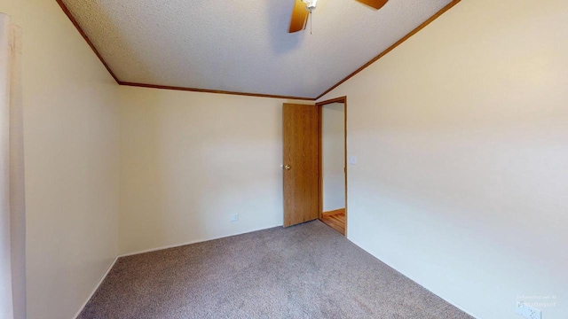 carpeted empty room with ceiling fan, vaulted ceiling, a textured ceiling, and ornamental molding