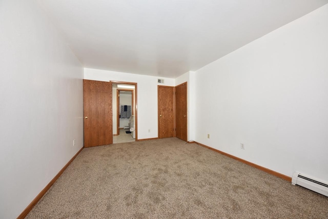 unfurnished bedroom with carpet flooring and a baseboard heating unit