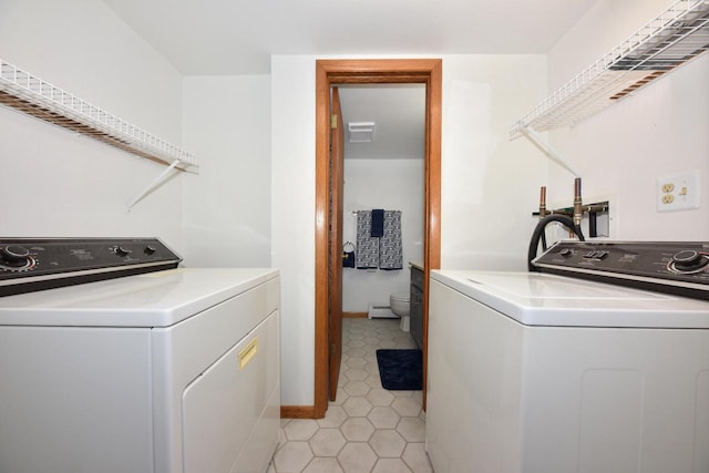 washroom with washer and clothes dryer and light tile patterned floors