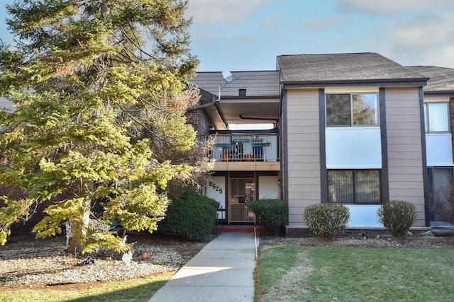 townhome / multi-family property featuring a balcony and a front yard