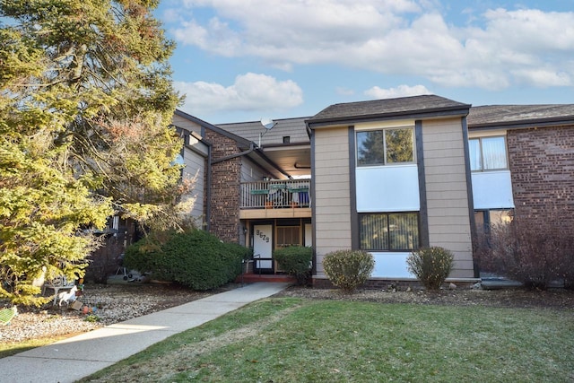 view of property with a front yard and a balcony