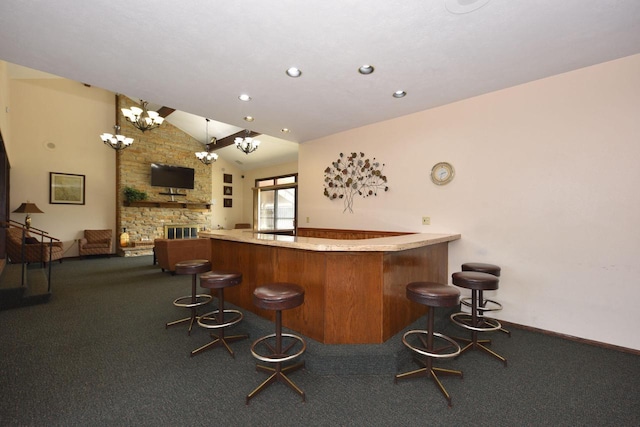 bar with pendant lighting, high vaulted ceiling, and a stone fireplace