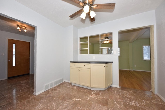 kitchen featuring cream cabinetry and a textured ceiling