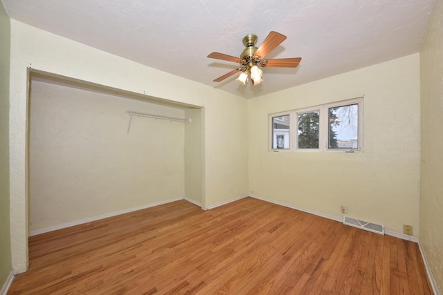 spare room with ceiling fan and light wood-type flooring