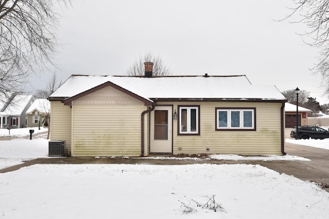 snow covered house with central air condition unit