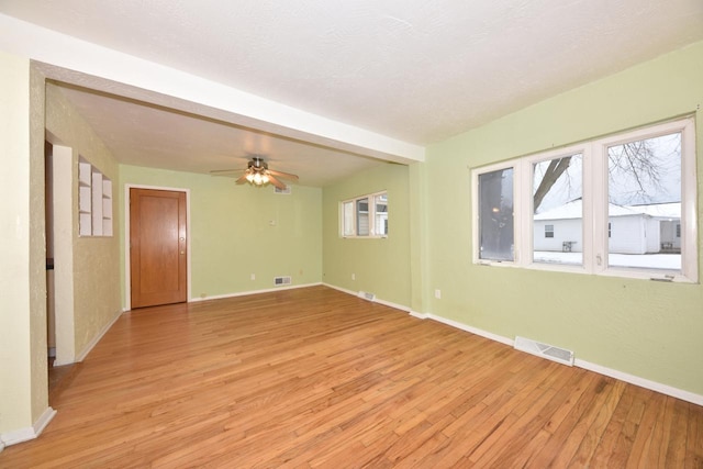 unfurnished room featuring ceiling fan, a textured ceiling, and light wood-type flooring