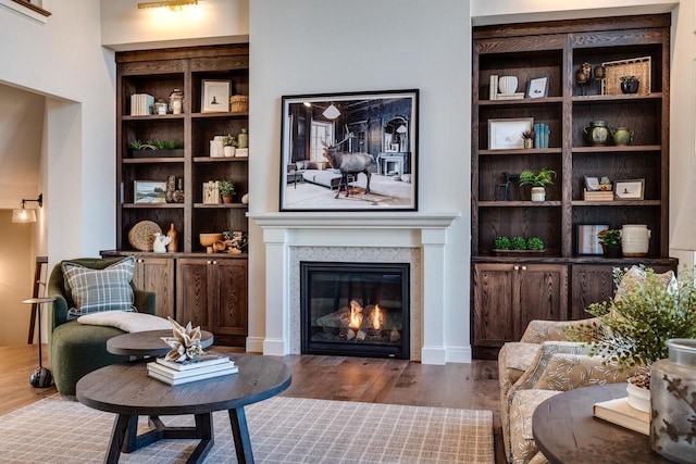 sitting room featuring built in shelves and dark hardwood / wood-style floors