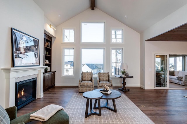 living room with beam ceiling, dark wood-type flooring, and high vaulted ceiling