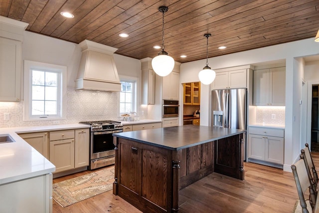 kitchen featuring premium range hood, a center island, hanging light fixtures, wooden ceiling, and appliances with stainless steel finishes