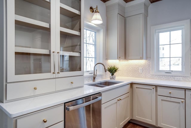 kitchen featuring white cabinetry, dishwasher, sink, and backsplash