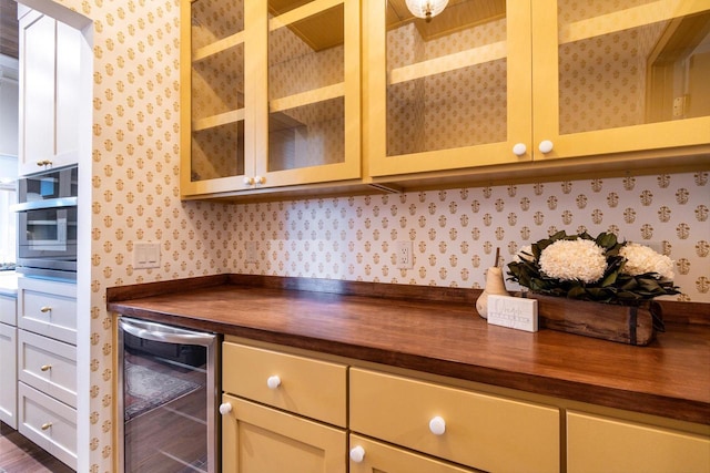 kitchen with white cabinetry, beverage cooler, and wooden counters