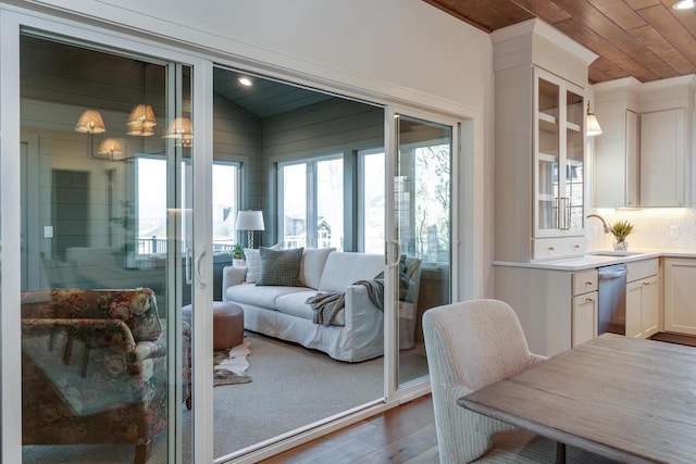 interior space with hardwood / wood-style flooring, sink, vaulted ceiling, and wooden ceiling