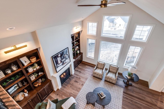 living room with ceiling fan, plenty of natural light, vaulted ceiling, and wood-type flooring