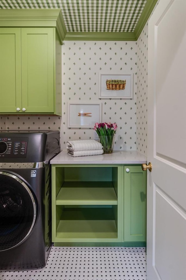 washroom with cabinets, ornamental molding, and washer / dryer