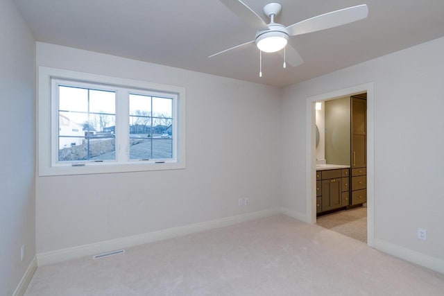 carpeted spare room with ceiling fan