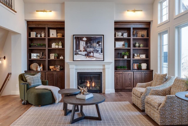 living room with wood-type flooring, a wealth of natural light, and built in features