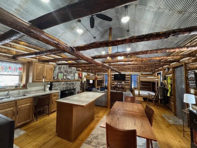 kitchen with ceiling fan, sink, a kitchen island, and light hardwood / wood-style flooring