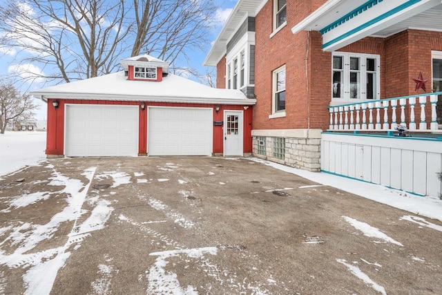 view of snowy exterior with a garage