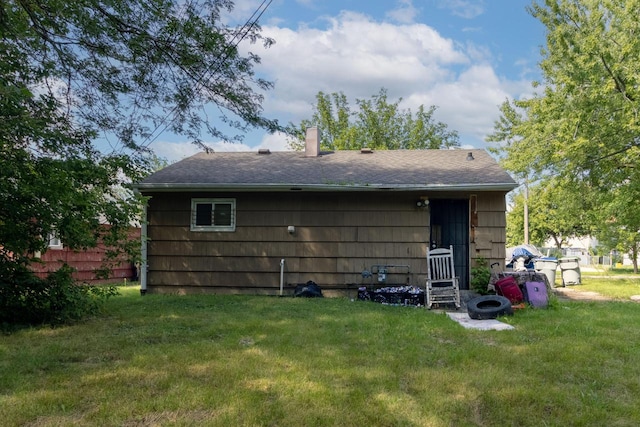 rear view of property featuring a lawn