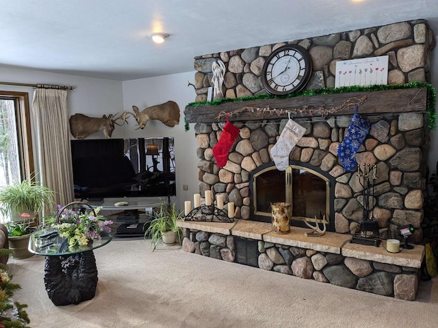 living room with carpet and a stone fireplace