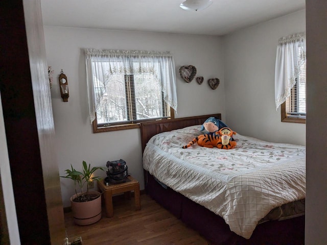 bedroom with hardwood / wood-style flooring and multiple windows