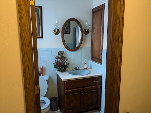 bathroom featuring vanity, toilet, and tile walls