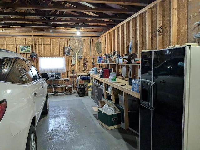 garage featuring a workshop area and black fridge