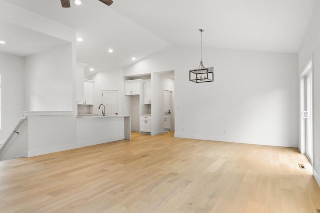 unfurnished living room with ceiling fan, light hardwood / wood-style flooring, lofted ceiling, and sink