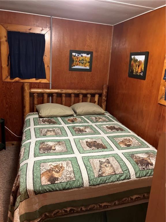 bedroom featuring wooden walls