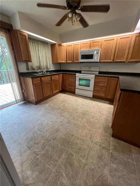 kitchen featuring ceiling fan, sink, and white appliances