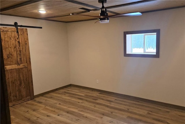 spare room with hardwood / wood-style floors, a barn door, and wood ceiling