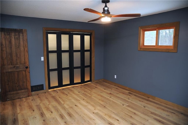 unfurnished bedroom with ceiling fan and light wood-type flooring