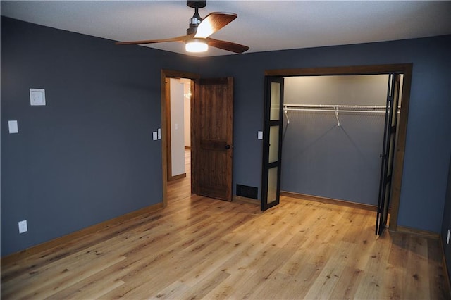 unfurnished bedroom with ceiling fan, light wood-type flooring, and a closet